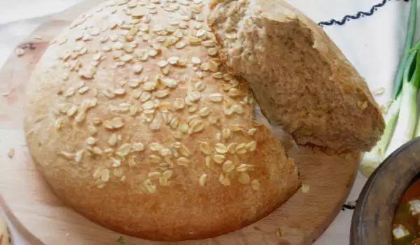 Пълнозърнест хляб с овесени ядки в керамичен съд