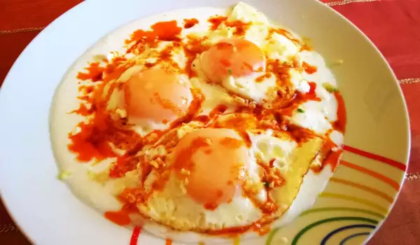 Пържени яйца върху кисело мляко и сирене