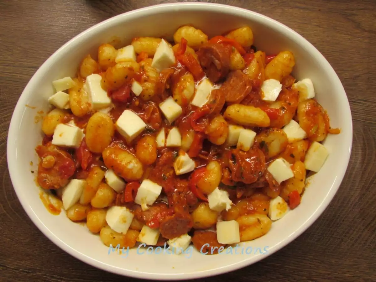 Разпределете в чинии картофени ньоки с доматен сос и чоризо